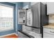 Modern stainless steel refrigerator and freezer with white cabinetry and granite countertops in this sleek kitchen at 4874 Seldon Se Way, Smyrna, GA 30080