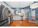 Modern kitchen with stainless steel appliances, white cabinets, hardwood flooring, granite countertops, and bright lighting at 4874 Seldon Se Way, Smyrna, GA 30080