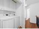 A well lit laundry room featuring white washer and dryer with white cabinets for storage at 4874 Seldon Se Way, Smyrna, GA 30080