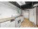 Basement kitchen featuring white appliances and cabinets and a doorway to a bathroom with shower and tub at 1649 Nw Ezra Church Nw Dr, Atlanta, GA 30314