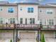 Rear view featuring private balconies, ground-level garages, and uniform siding on attached townhomes at 20057 Windalier Way, Roswell, GA 30076