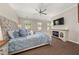 Bright bedroom featuring a fireplace, ceiling fan and large bed with hardwood floors at 20057 Windalier Way, Roswell, GA 30076