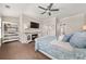 Comfortable bedroom with a ceiling fan, TV over a fireplace, and hardwood floors at 20057 Windalier Way, Roswell, GA 30076