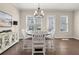 Cozy dining room with a round table, white chairs, and a view of the backyard through the windows at 20057 Windalier Way, Roswell, GA 30076