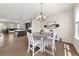 Open dining room with a round table, white chairs, decorative chandelier, and views into the living and kitchen areas at 20057 Windalier Way, Roswell, GA 30076