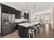 Modern kitchen featuring dark cabinetry, stainless steel appliances, and a center island with seating at 20057 Windalier Way, Roswell, GA 30076