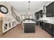Modern kitchen boasts dark cabinets, stainless steel appliances, hardwood floors and a large island overlooking the living area at 20057 Windalier Way, Roswell, GA 30076