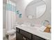 Well-lit bathroom with a vanity and a tub with a decorative shower curtain at 432 Providence Walk St, Canton, GA 30114