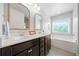 Bright bathroom with double vanity, dark cabinets, and a soaking tub by the window at 432 Providence Walk St, Canton, GA 30114