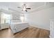 Bright bedroom features hardwood floors, a ceiling fan, a tray ceiling, and white painted shiplap walls at 432 Providence Walk St, Canton, GA 30114