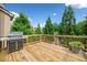 A wooden deck is shown with a grill and a potted plant overlooking a lush green yard with trees at 432 Providence Walk St, Canton, GA 30114