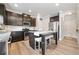 Well-lit kitchen featuring stainless steel appliances, dark cabinetry, and an island with barstool seating at 432 Providence Walk St, Canton, GA 30114