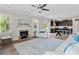 Open living room with a fireplace, ceiling fan, and an adjacent kitchen with a breakfast bar at 432 Providence Walk St, Canton, GA 30114