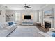 Cozy living room with a fireplace, plush white seating, and a ceiling fan at 432 Providence Walk St, Canton, GA 30114