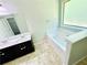 Bright bathroom featuring soaking tub, double vanity, and modern fixtures at 4417 Belcamp Rd, Fairburn, GA 30213