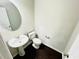 Bathroom with pedestal sink, toilet, and dark hardwood floors at 4417 Belcamp Rd, Fairburn, GA 30213