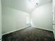 Bright bedroom featuring plush carpet, vaulted ceiling, and window views at 4417 Belcamp Rd, Fairburn, GA 30213