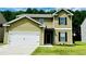 Two-story home with green siding, two-car garage, and a well-manicured lawn and landscape at 4417 Belcamp Rd, Fairburn, GA 30213