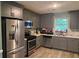 Updated kitchen with stainless steel appliances, gray cabinets, and ample counter space at 2433 Robin Ridge Dr, Dacula, GA 30019