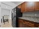 Well-lit kitchen featuring granite countertops, wood cabinets, a black refrigerator, and a dining area at 2479 Peachtree Ne Rd # 301, Atlanta, GA 30305