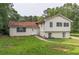 Charming split-level home featuring a brick facade, red roof, and a spacious front yard at 4408 Shiloh Trl, Powder Springs, GA 30127
