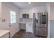 Bright kitchen with stainless steel refrigerator, microwave, and white cabinetry with workspace at 4408 Shiloh Trl, Powder Springs, GA 30127