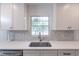 Close-up of a stainless steel sink with stylish faucet and elegant white countertops at 4408 Shiloh Trl, Powder Springs, GA 30127