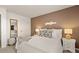 Bedroom featuring a white bed with stylish pillows, a tan accent wall, and elegant white furniture at 1622 Palladian Way, Lithonia, GA 30058