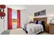 A bedroom with hardwood headboard, red curtains, natural light, and sports-themed decor at 1622 Palladian Way, Lithonia, GA 30058