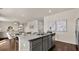 An open-concept kitchen island features a granite countertop with a sink, gray cabinets, and seating for modern living at 1622 Palladian Way, Lithonia, GA 30058