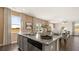 A modern kitchen island features granite countertops, gray cabinets, stainless dishwasher, and a view into the living area at 1622 Palladian Way, Lithonia, GA 30058
