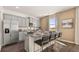 An open kitchen features gray cabinets, granite countertops, stainless steel appliances, and a large island with bar seating at 1622 Palladian Way, Lithonia, GA 30058