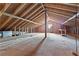 Unfinished attic space shows exposed wood beams, ductwork, a small window, and a table against one wall at 195 Blackberry Run, Fayetteville, GA 30214