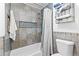 Bathroom with tiled shower over tub, neutral color palette, and towel storage at 195 Blackberry Run, Fayetteville, GA 30214