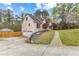 A single-story home surrounded by trees features a long driveway and lush lawn at 195 Blackberry Run, Fayetteville, GA 30214