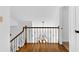 Hallway showcasing wrought iron railing with view of chandelier and staircase below at 195 Blackberry Run, Fayetteville, GA 30214