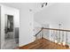 Hallway with wood railing and staircase leading to a bathroom with a shower-tub combo at 195 Blackberry Run, Fayetteville, GA 30214