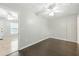 Neutral bedroom featuring hardwood floors, a ceiling fan, and a glimpse into another room at 314 Spring Falls Drive, Lawrenceville, GA 30045