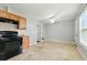 Bright kitchen featuring tile floors, ceiling fan, black stove and light wood cabinetry at 314 Spring Falls Drive, Lawrenceville, GA 30045