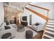Bright living room featuring exposed brick, modern furniture, and an open floor plan to the kitchen and stairs to the second floor at 320 Martin Luther King Jr Se Dr # 9, Atlanta, GA 30312