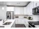 Well-lit kitchen with white cabinetry, a stainless steel refrigerator, and modern countertops and backsplash at 3351 Orwell Way # 2301, Cumming, GA 30041