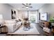 Modern living room features a sectional sofa, a patterned rug, and a large TV with natural lighting at 3351 Orwell Way # 2301, Cumming, GA 30041
