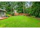 Well manicured lawn with wooden fence, landscaping and mature trees at 3770 Wake Robin Way, Cumming, GA 30028