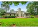 Backyard featuring a manicured lawn, mature landscaping, and a wooden patio at 3770 Wake Robin Way, Cumming, GA 30028