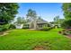 Backyard featuring a manicured lawn, a wooden patio, and mature trees at 3770 Wake Robin Way, Cumming, GA 30028