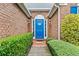 Inviting front entrance with a bright blue door framed by manicured hedges at 3770 Wake Robin Way, Cumming, GA 30028