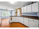 Cozy kitchen with white cabinetry, stainless steel sink and wood-look flooring at 3770 Wake Robin Way, Cumming, GA 30028