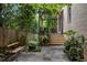 Charming backyard with stone patio, wooden bench, pergola, and stairs leading to a seating area surrounded by greenery at 92 Old Ivy Ne Rd # 6, Atlanta, GA 30342