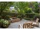 Charming backyard with stone patio, lush greenery, and decorative water feature at 92 Old Ivy Ne Rd # 6, Atlanta, GA 30342