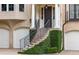 Elegant home entrance featuring a curved staircase with wrought iron railings and lush greenery at 92 Old Ivy Ne Rd # 6, Atlanta, GA 30342